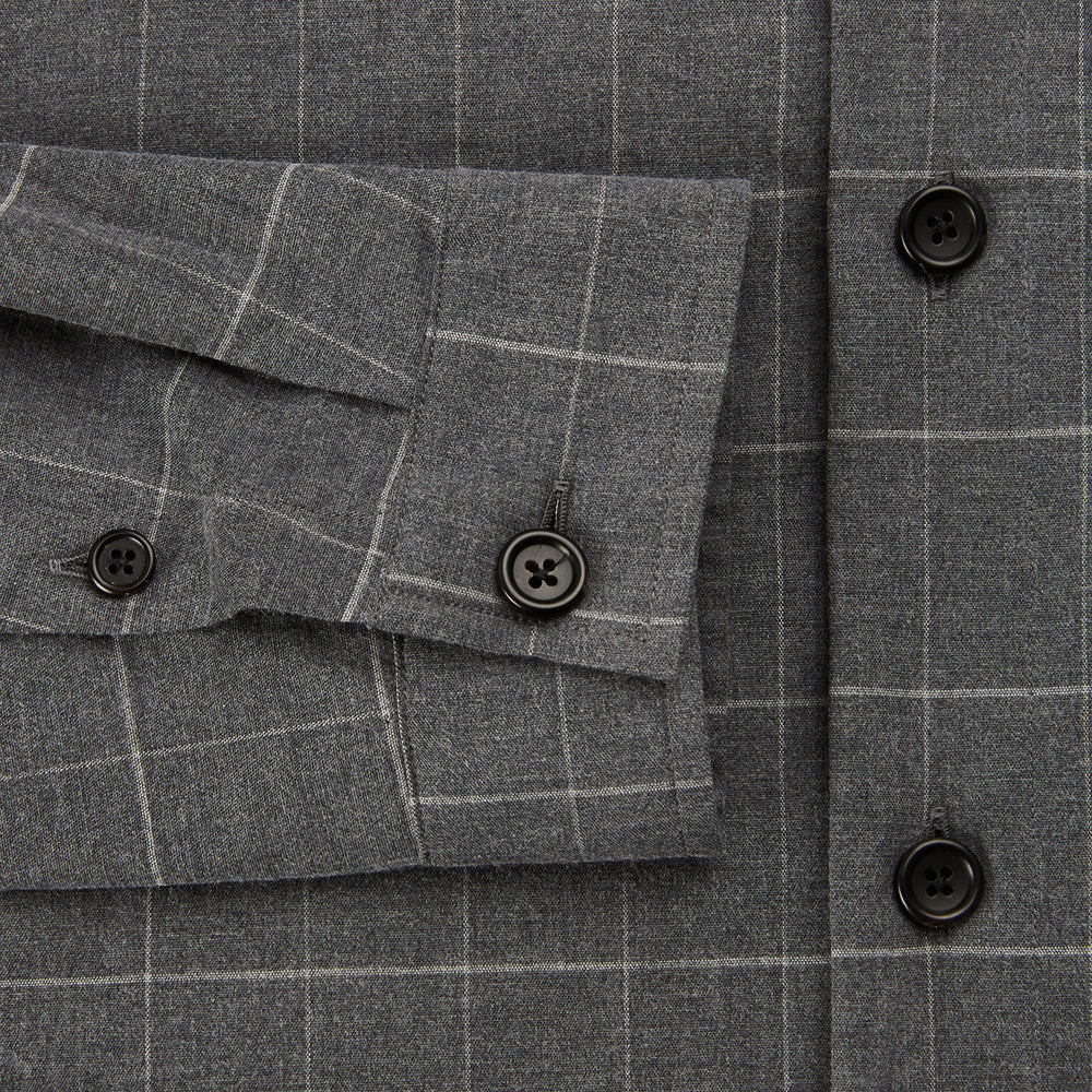 The Turnbull & Asser Charcoal Melange Check Hampstead overshirt, a long-sleeve button-up with a collar and two zippered side pockets, is laid flat on a light gray background.