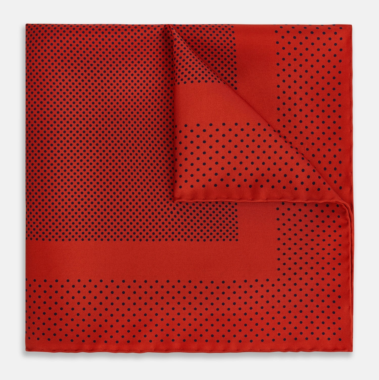 View 1 of product The Turnbull & Asser Red Dot Silk Pocket Square showcases small black dots on red silk, neatly folded to reveal both the front and part of the reverse side.