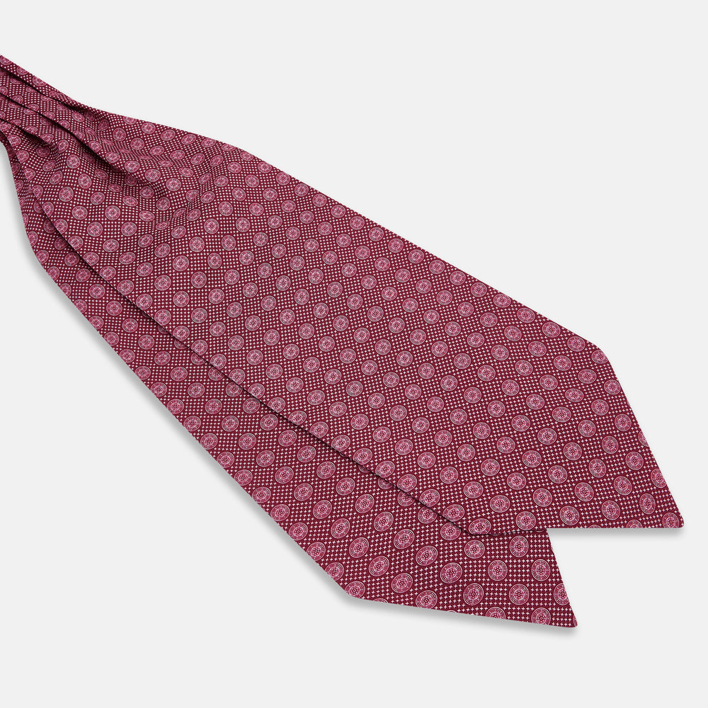 The Burgundy Medallion Silk Cravat by Turnbull & Asser features a white geometric medallion pattern, neatly crafted for an elegant accessory inspired by classic British style.