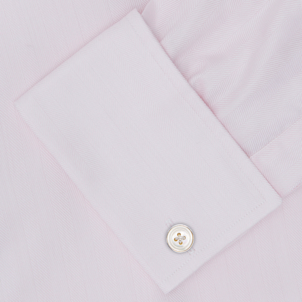 The Turnbull & Asser Pink Herringbone Superfine Cotton Shirt features a T&A collar, double cuffs, and clean-cut design, displayed neatly folded against a white background.