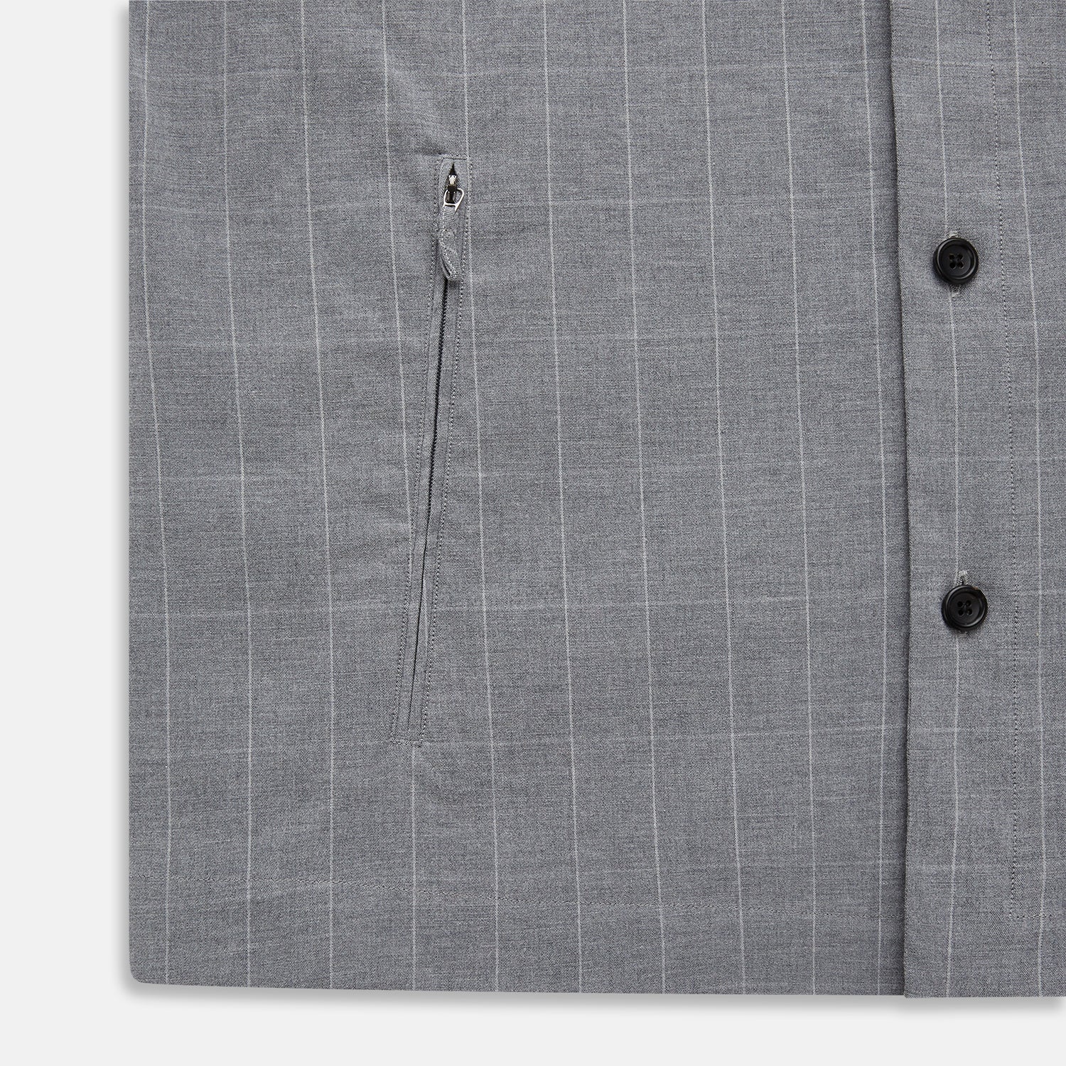 View 7 of product The Turnbull & Asser Grey Check Hampstead Overshirt features a light gray check pattern, pointed collar, chest pocket, and two zippered side pockets, displayed flat against a white background.