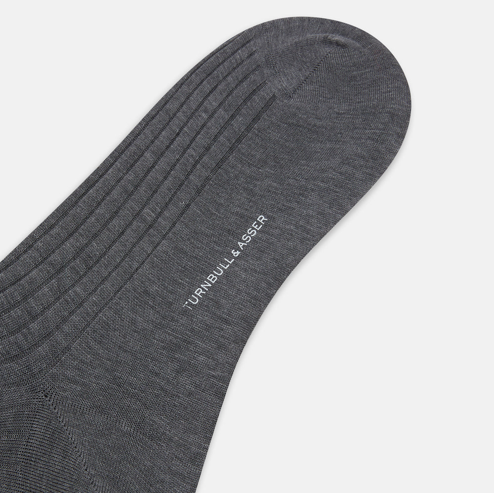 The Turnbull & Asser Steel Melange Mid-Length Sock, in dark gray ribbed mercerised Egyptian cotton, is shown upright on a white background to highlight its elegant shape and texture.