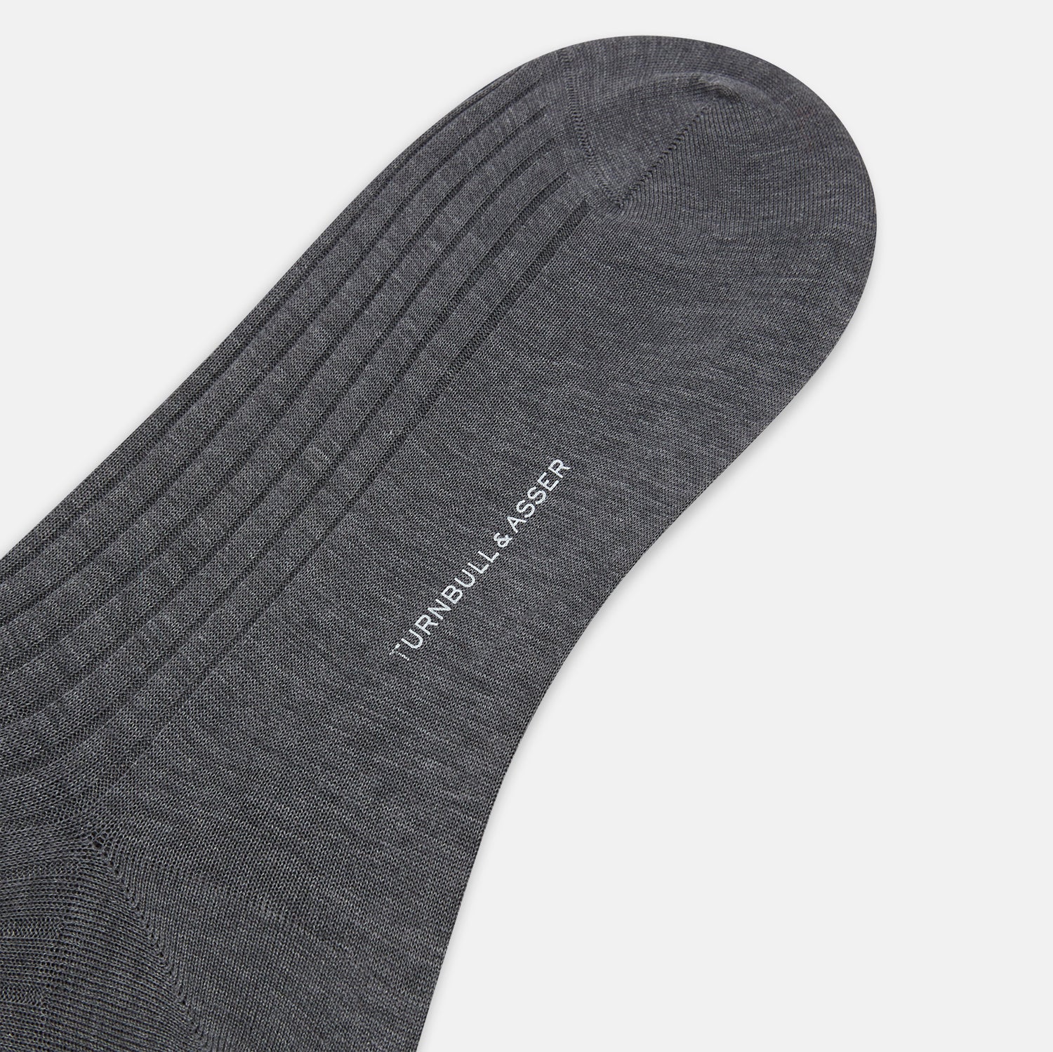 View 4 of product The Turnbull & Asser Steel Melange Mid-Length Sock, in dark gray ribbed mercerised Egyptian cotton, is shown upright on a white background to highlight its elegant shape and texture.