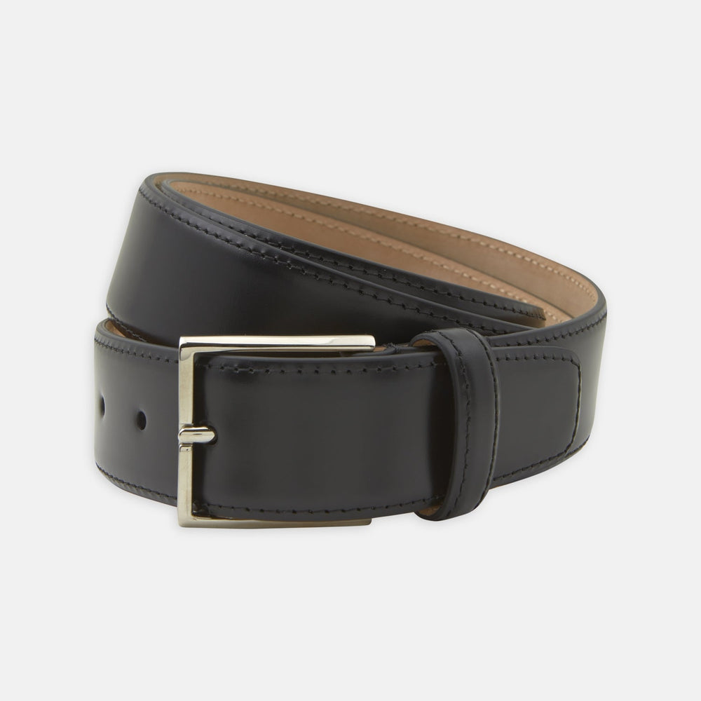 The Turnbull & Asser Black Nubuck Leather Evening Belt features a coiled design, silver rectangular buckle, and tan interior, elegantly displayed against a plain white background.