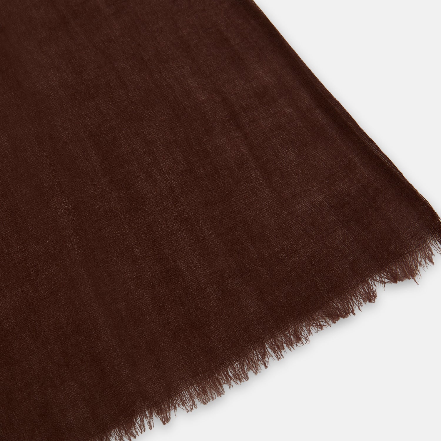 View 2 of product The Turnbull & Asser Dark Chocolate Cashmere Scarf is neatly folded with fringed edges and loose ends, showcasing its lightweight, luxurious fabric on a plain white background.
