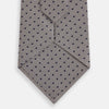 View 3 of product The Turnbull & Asser Navy and Lilac Micro Dot Silk Tie is shown rolled up on a white background, featuring a refined pattern of small lilac dots on navy silk.