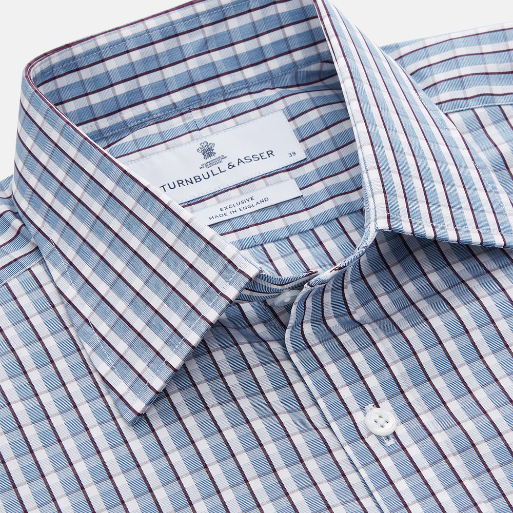 The Turnbull & Asser Blue and White Check Cotton Regular Fit Mayfair Shirt features long sleeves, a pointed collar, and buttoned cuffs, shown here on a white background.