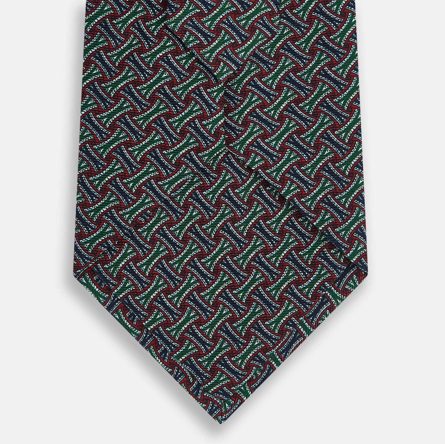 View 3 of product The Forest Green and Red Weave Patterned Silk Tie by Turnbull & Asser features a geometric interlocking design in red, blue, and green, elegantly rolled on a white background.