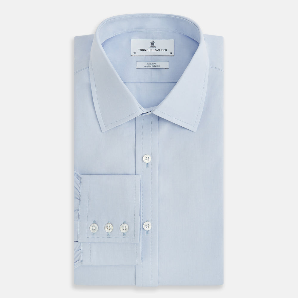 The Pale Blue Mayfair Shirt by Turnbull & Asser is a long-sleeve, button-up dress shirt with a pointed collar and buttoned cuffs, crafted from sanforised cotton and shown laid flat on a white background.