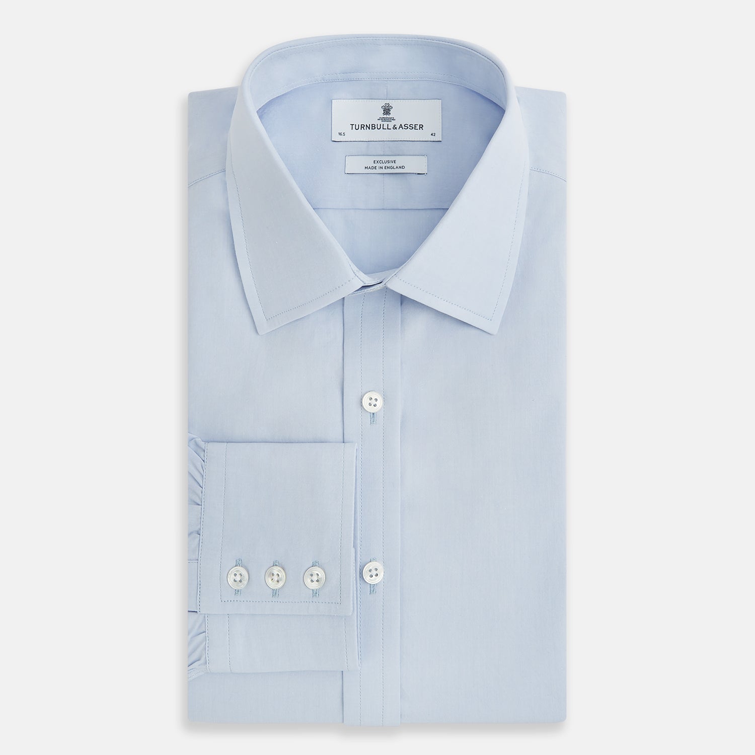 View 5 of product The Pale Blue Mayfair Shirt by Turnbull & Asser is a long-sleeve, button-up dress shirt with a pointed collar and buttoned cuffs, crafted from sanforised cotton and shown laid flat on a white background.