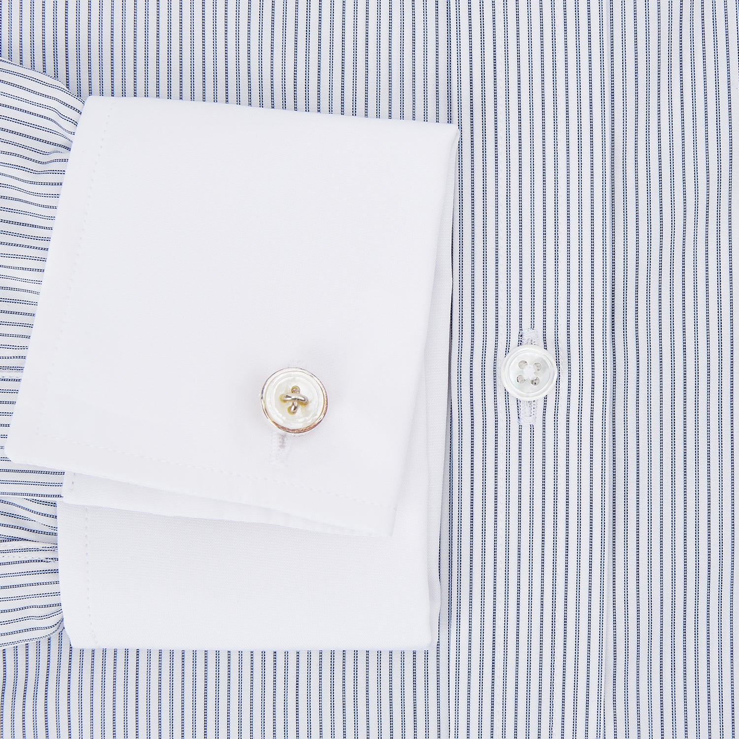 View 4 of product The Turnbull & Asser Navy and Blue Ticking Stripe Shirt features a contrast white collar and double cuffs, displayed on a plain white background. Tailored in the sleek Mayfair fit, it’s ideal for formal attire.