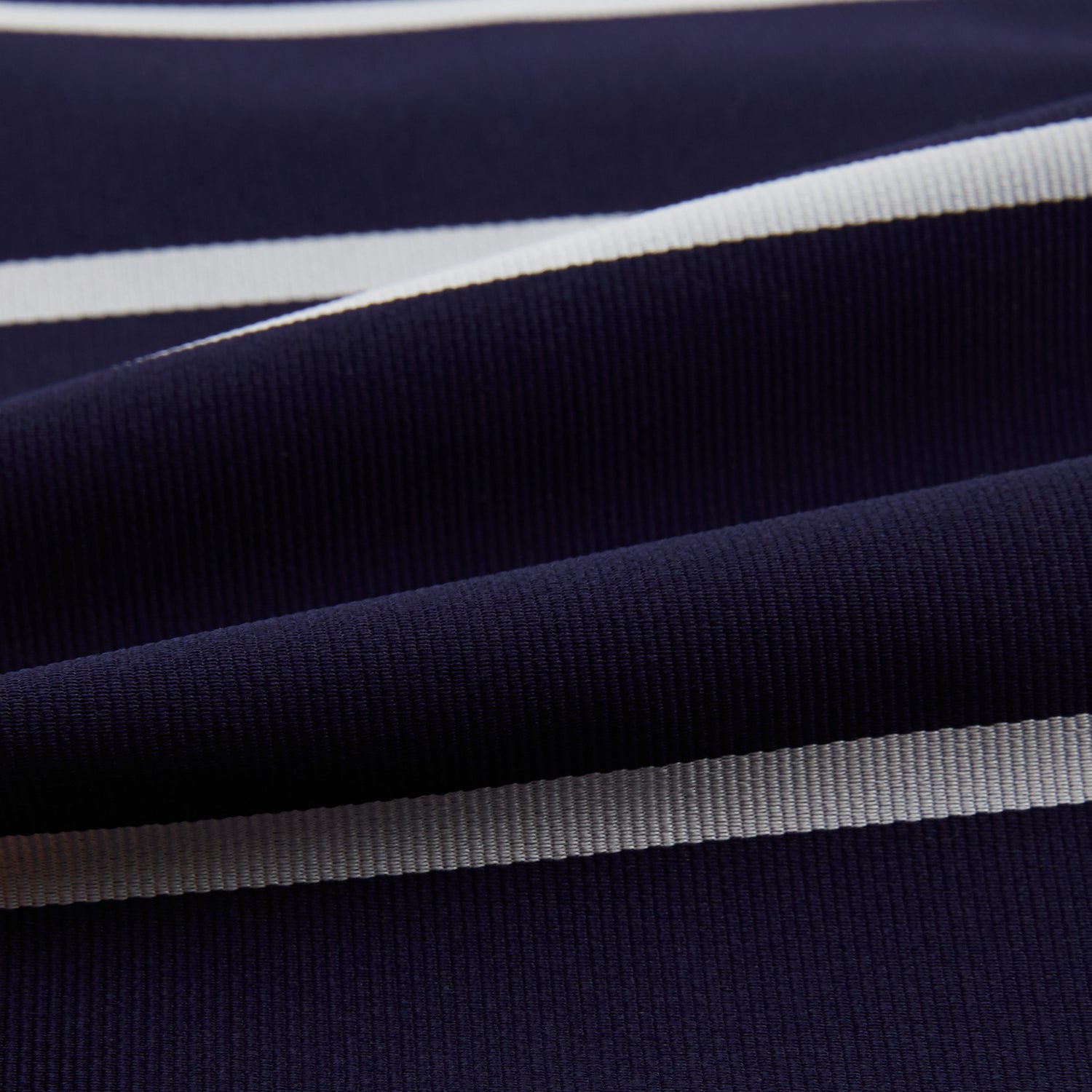 View 4 of product The Turnbull & Asser Silver Stripe and Navy Silk Cravat features two horizontal white stripes on navy silk, offering a sophisticated British-inspired design—ideal as a unique wedding accessory.