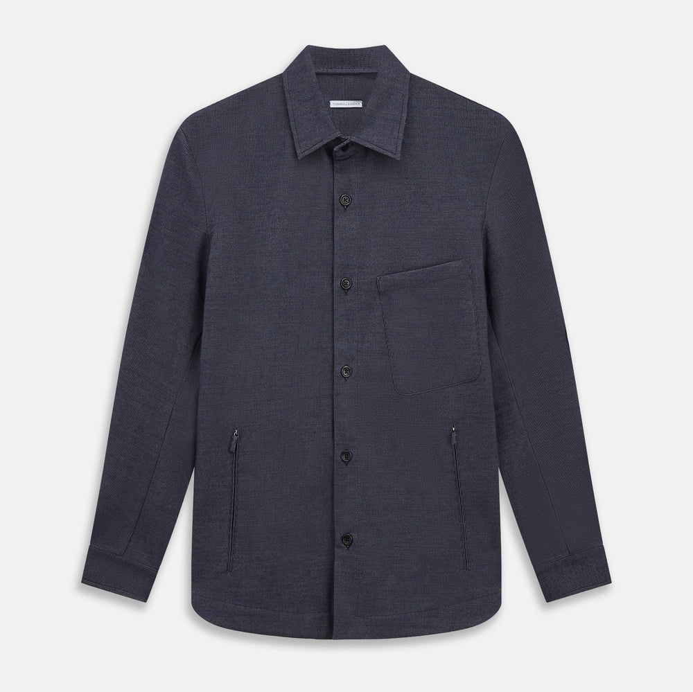 The Turnbull & Asser Navy Hampstead Overshirt features a collar, left chest pocket, two zippered pockets near the bottom, and a classic long-sleeve button-up design, shown laid flat on a white background.