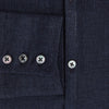 View 4 of product The Navy Linen Windsor Shirt by Turnbull & Asser features long sleeves, white buttons, a Turnbull collar, and buttoned cuffs in dark navy blue linen. Shown laid flat on a white background.