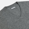 View 2 of product The Turnbull & Asser Grey Melange Cashmere V-neck Jumper features long sleeves, ribbed cuffs and hem, showcasing timeless style against a white background.