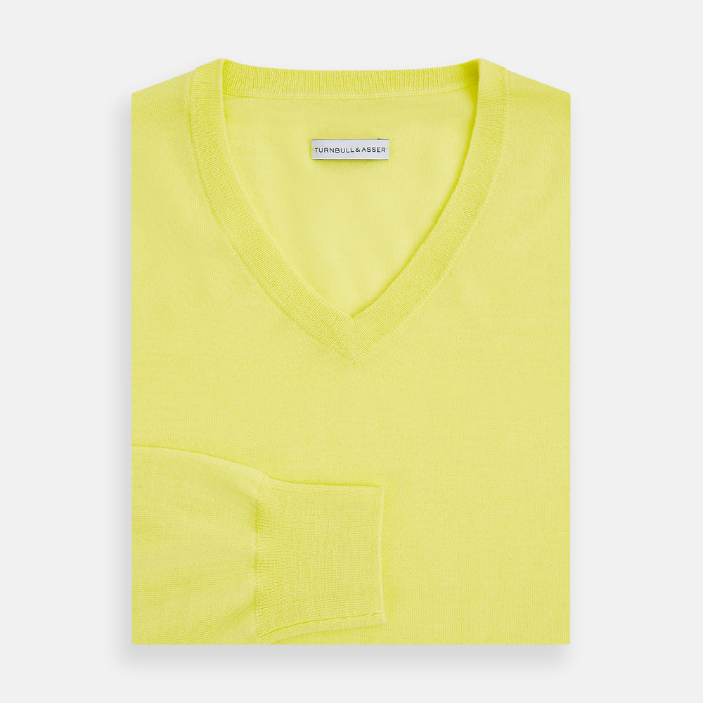The Turnbull & Asser Bright Yellow Cashmere V-neck Jumper, a plain long-sleeved knitwear sweater, is showcased against a white background.