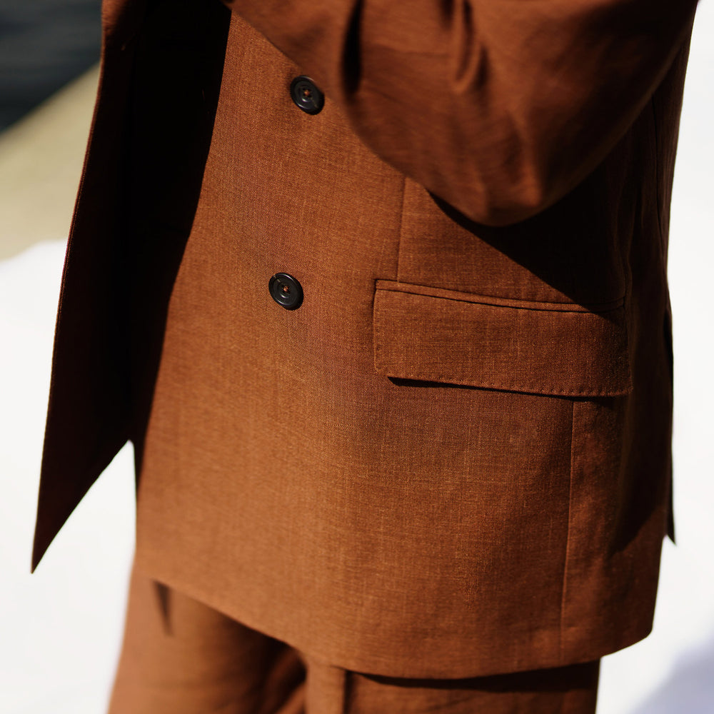 The Turnbull & Asser Rust Linen-Wool-Silk Bertie Blazer is a red double-breasted jacket with peak lapels, black buttons, and flap pockets, tailored in Italy from a luxury linen-wool-silk blend and shown on a white background.
