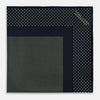 View 3 of product The Turnbull & Asser Navy and Melon Green Dot Silk Pocket Square features small melon green dots on navy silk with a solid border. One corner is folded over to highlight its exquisite handmade craftsmanship.
