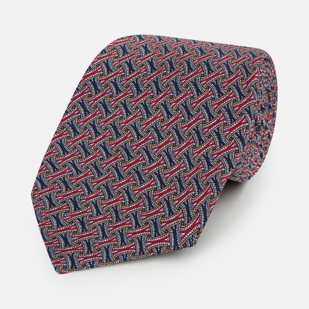 The Turnbull & Asser Burgundy and Navy Weave Patterned Silk Tie features a geometric design in rich tones on silk fabric.