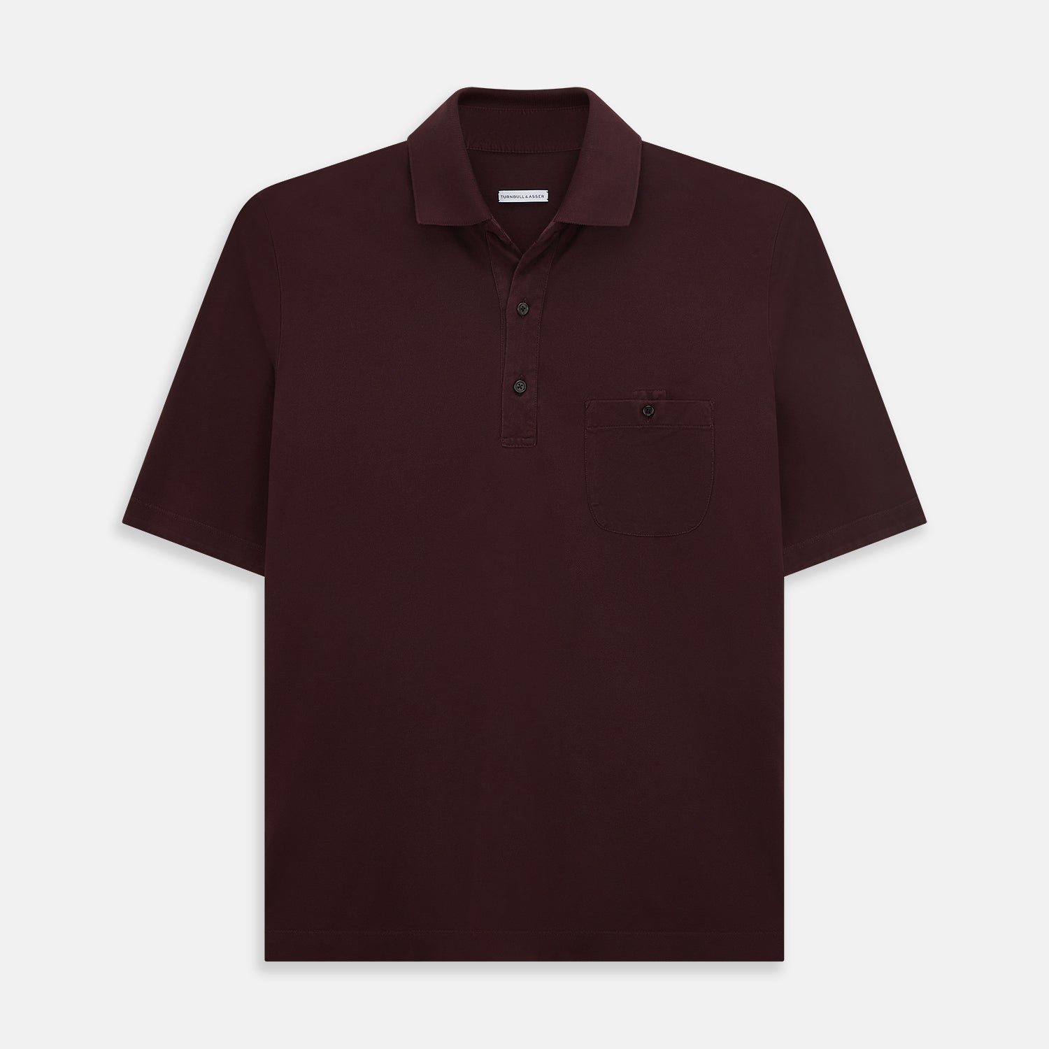 View 1 of product The Turnbull & Asser Burgundy Polo Shirt is crafted from soft cotton jersey with short sleeves, a classic collar, three front buttons, and a small buttoned chest pocket, shown flat on a white background.