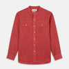 View 1 of product The Turnbull & Asser Plain Red Linen Weekend Fit Shirt with Stand Collar features long sleeves, a button-up front, and two buttoned-flap chest pockets. It is shown neatly laid flat on a plain light background.