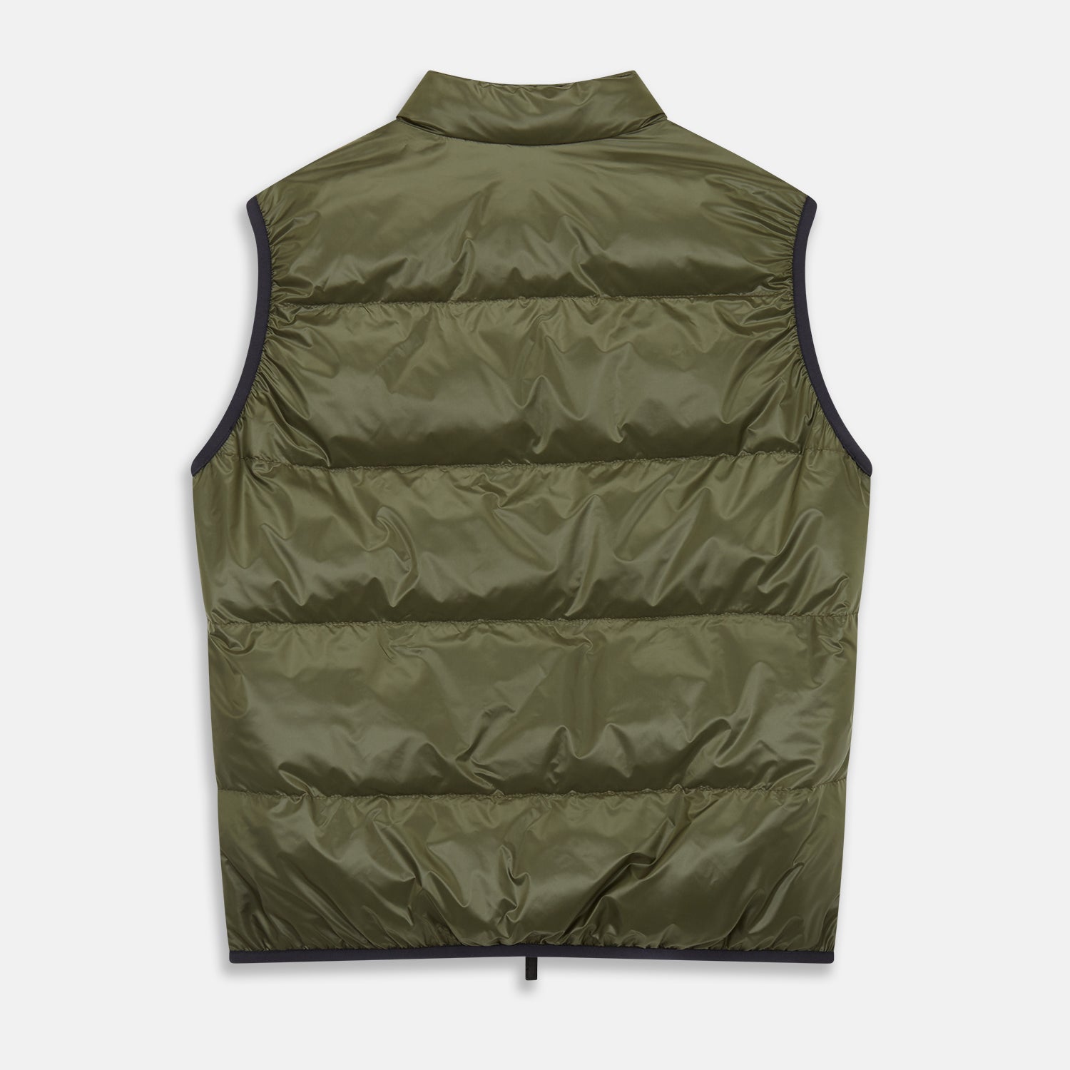 View 7 of product A man stands against a plain background wearing the Turnbull & Asser Green Peyton Sealup Quilted Gilet over a striped shirt, dark trousers, and white sneakers, with his hands in his pockets and looking slightly to the side.