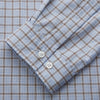 View 3 of product A man wearing glasses and a Pale Blue Multi Check Cashmerello Holiday Fit Winnington Shirt by Turnbull & Asser leans casually against a white countertop, looking at the camera with a neutral expression.