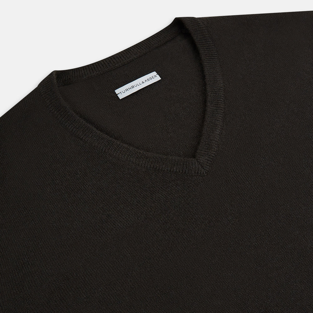 The Turnbull & Asser Dark Brown Cashmere V-Neck Jumper features long sleeves, ribbed cuffs, and a ribbed hem—timeless knitwear shown on a white background, perfect for elevating any wardrobe.