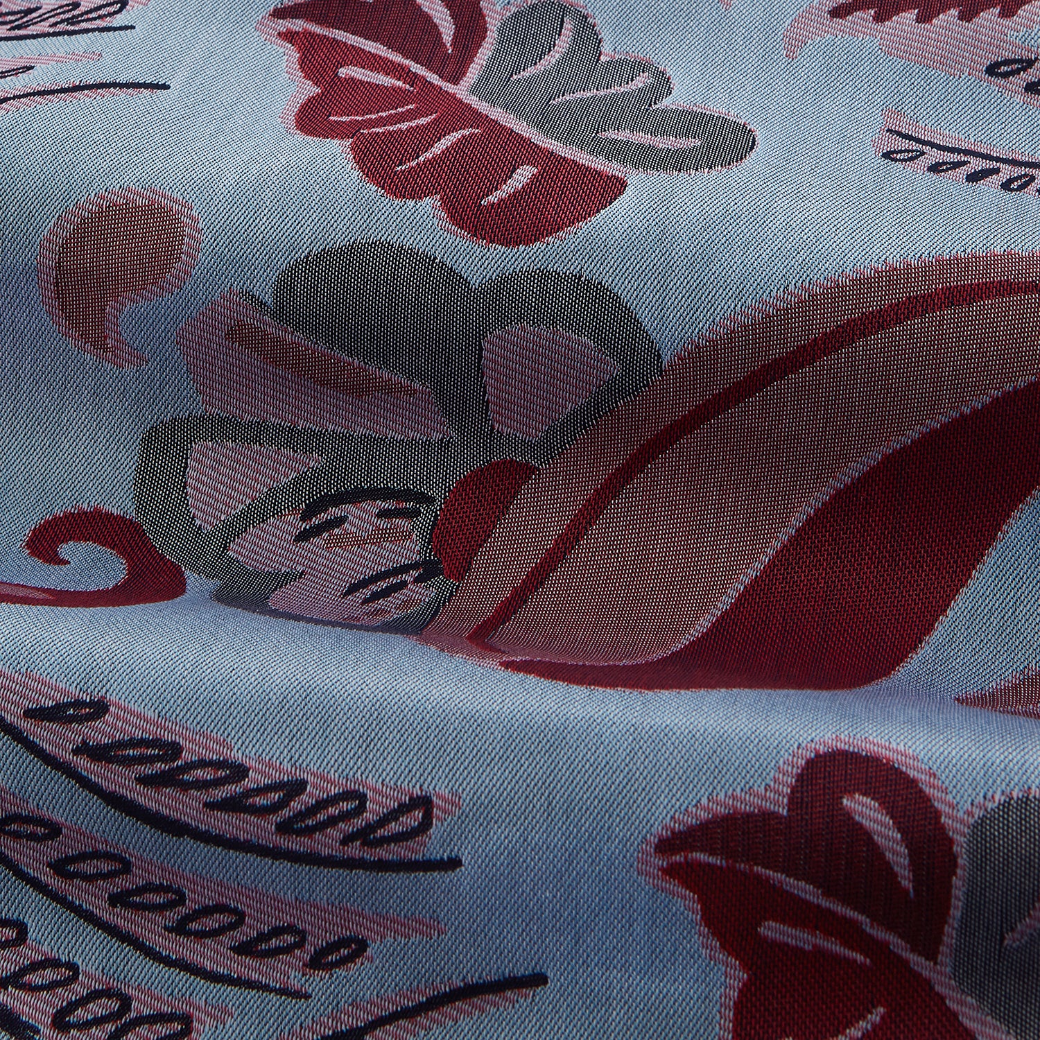 View 2 of product The Blue Paisley Pattern Cotton Arnold Gown by Turnbull & Asser features light blue jacquard cotton with a red and black paisley design, long sleeves, a matching belt, and two front pockets for a subtle Bloomsbury-inspired look.