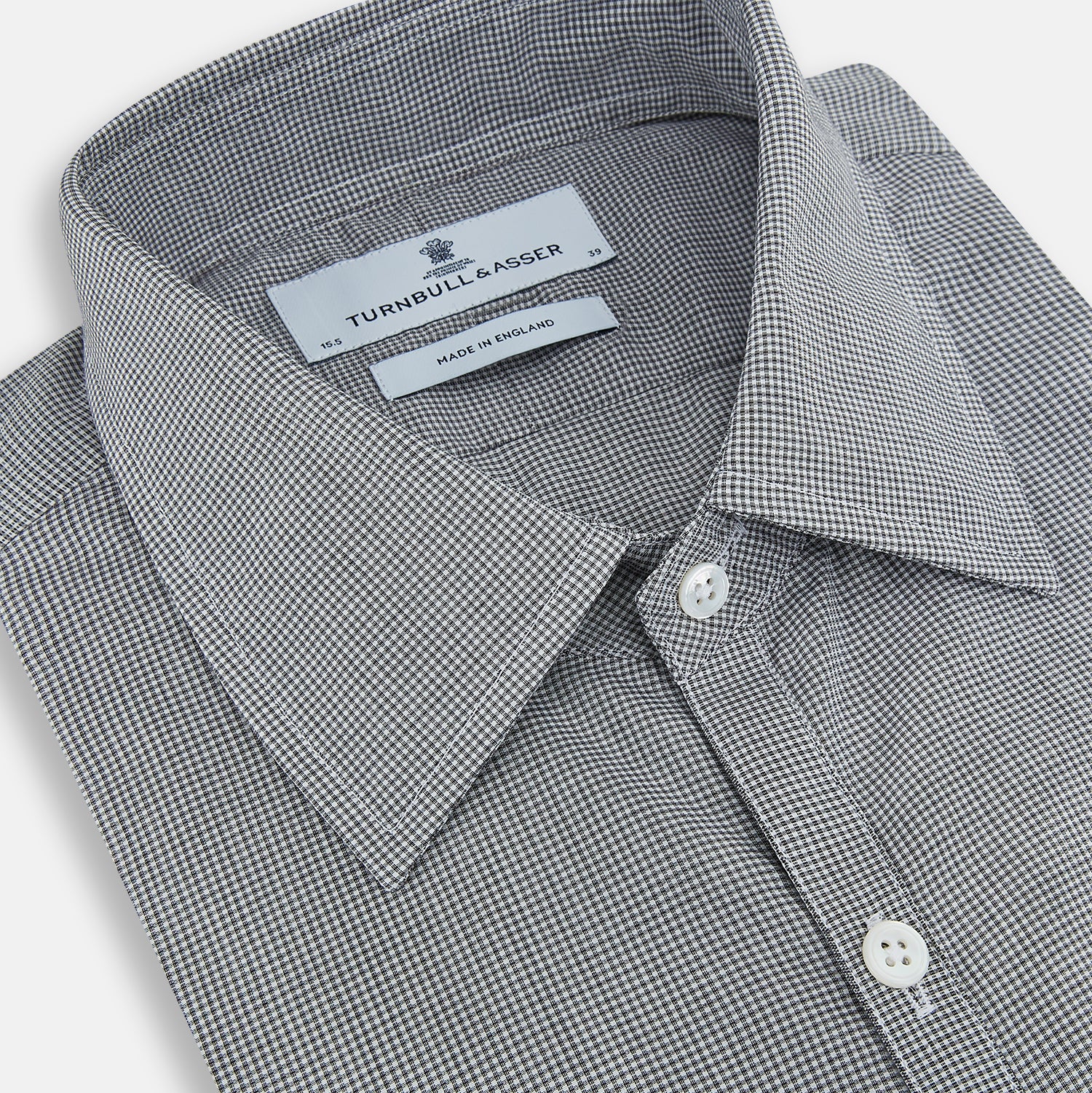 View 2 of product The Turnbull & Asser Grey and White Micro Check Westminster Shirt features long sleeves, a button-up front, a Westminster collar, and white buttons, shown flat on a white background.