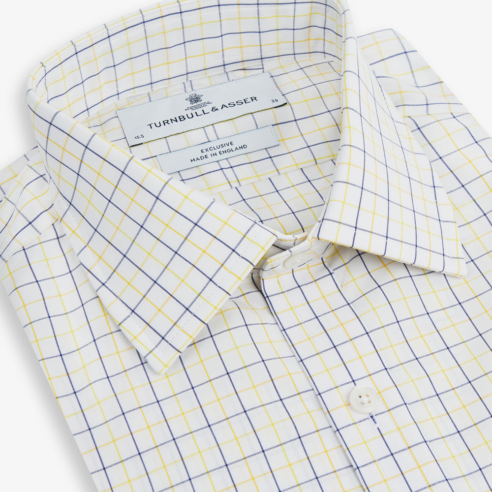 The Turnbull & Asser Yellow Overlay Grid Check Mayfair Shirt is a long-sleeve, button-down shirt made from soft organic cotton, featuring a yellow grid check pattern and shown laid flat on a white background.