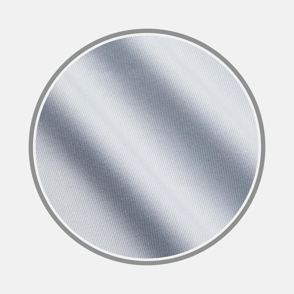 A close-up of Turnbull & Asser's Plain Grey Cotton Fabric shows its textured surface with diagonal lines and soft shadows, presented inside a circular frame on a white background.