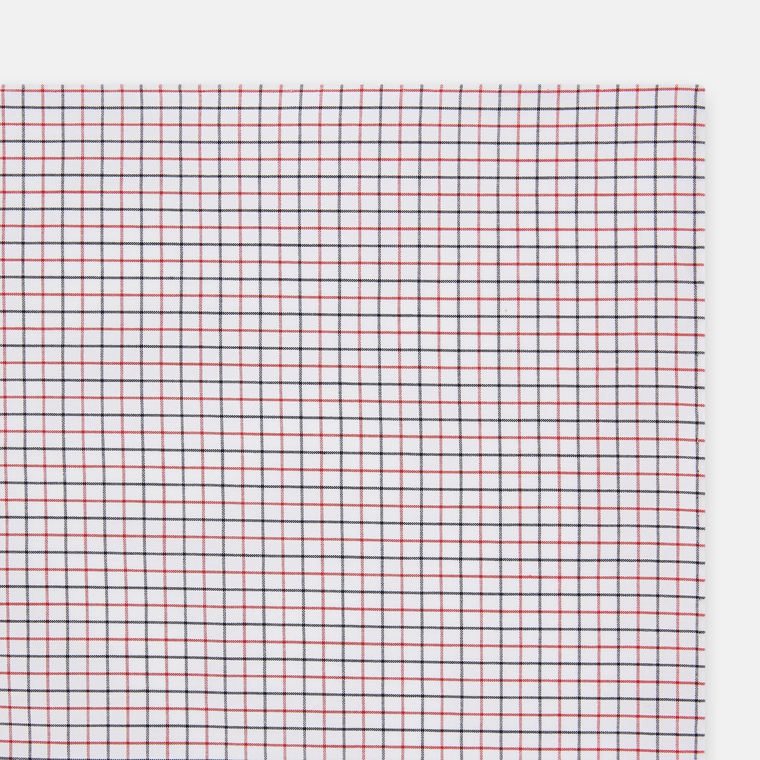View 2 of product Turnbull & Asser’s Hand Rolled Red and Navy Graph Check Handkerchief—a white cotton accessory with red and navy grid lines, neatly folded for a touch of refined elegance.
