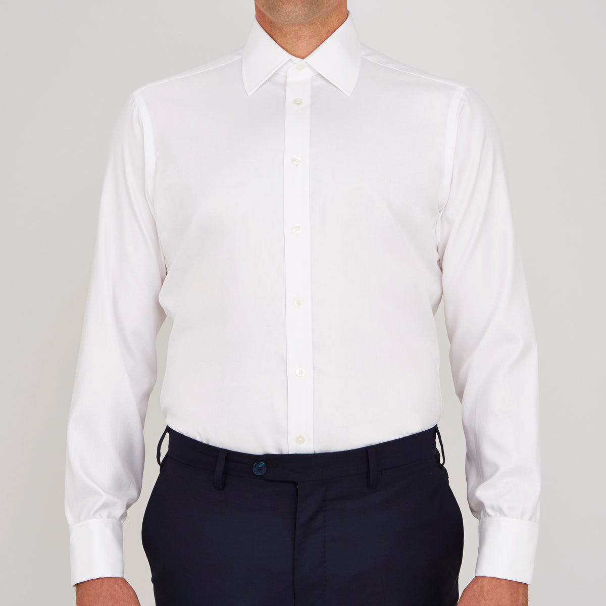View 2 of product A neatly folded Turnbull & Asser White Oxford Shirt with T&A collar and double cuffs is displayed on a light blue background.