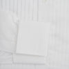View 3 of product The Turnbull & Asser White Pleated Cotton Dress Shirt features a T&A collar, double cuffs, a button-down front, elegant chest pleats, and a slightly curved hem for a classic formal look.