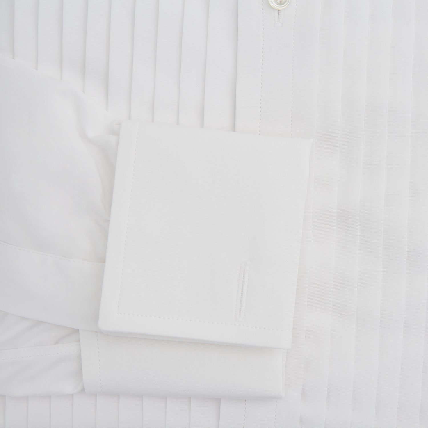 View 3 of product The Turnbull & Asser White Pleated Cotton Dress Shirt features a T&A collar, double cuffs, a button-down front, elegant chest pleats, and a slightly curved hem for a classic formal look.