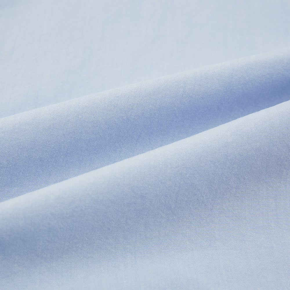 The Turnbull & Asser Pale Blue Hyde Overshirt is a long-sleeve, sanforised cotton button-up with a single chest pocket and dark buttons, shown on a plain white background.