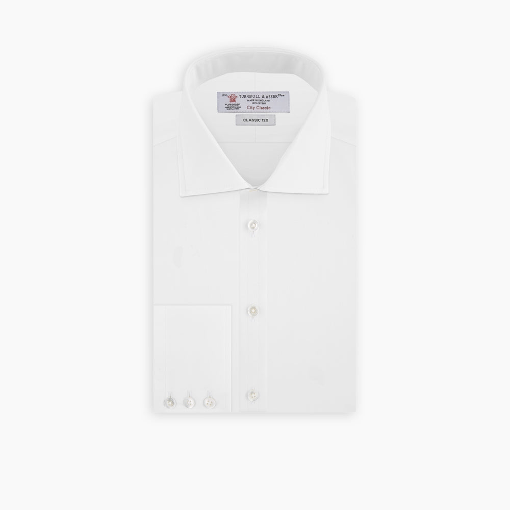 The Turnbull & Asser Two-Fold 120 White Shirt with a Regent collar and 3-button cuffs is neatly folded and displayed against a light blue background.