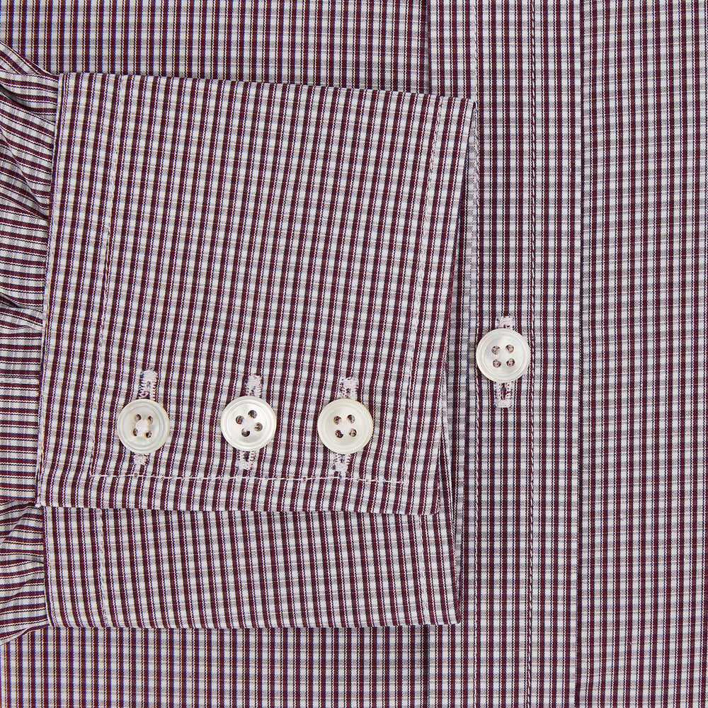 The Turnbull & Asser Burgundy Micro Check Mayfair Shirt features long sleeves, a pointed collar, and white buttons—perfect for formal wear. Shown laid flat on a white background.