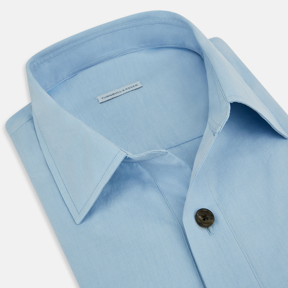The Blue Hyde Overshirt by Turnbull & Asser features a light blue hue, long sleeves, a button-up front, and a single chest pocket. Crafted from sanforised cotton and shown laid flat on a white background.