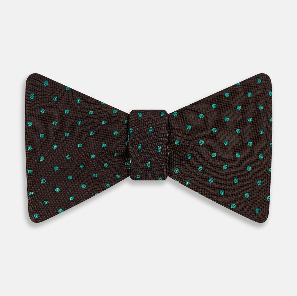 The Blue and Brown Micro Dot Silk Bow Tie by Turnbull & Asser features subtle blue micro dots on brown silk, photographed on a plain white background—a sophisticated men's accessory perfect for formal events.