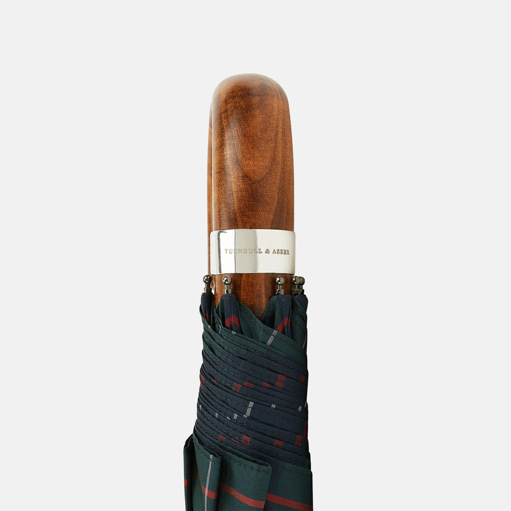 The Turnbull & Asser Colquhoun Tartan Telescopic Umbrella features a green, blue, and red plaid canopy, a durable metal shaft, and a brown maple crook handle, displayed against a plain light background.