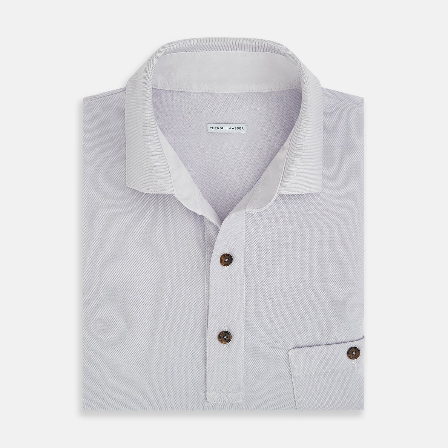 View 4 of product A soft pink cotton polo shirt by Turnbull & Asser features short sleeves, a contrasting white collar, three dark buttons, and a left chest pocket. Laid flat on a white background—it’s perfect for modern men’s fashion.