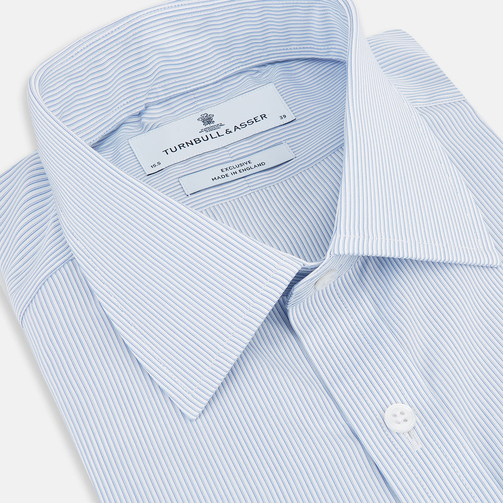 The Turnbull & Asser Sky Blue Hairline Multi Stripe Mayfair Shirt features Italian cotton, long sleeves, a classic collar, white buttons, and a subtle stripe pattern, shown on a plain white background.