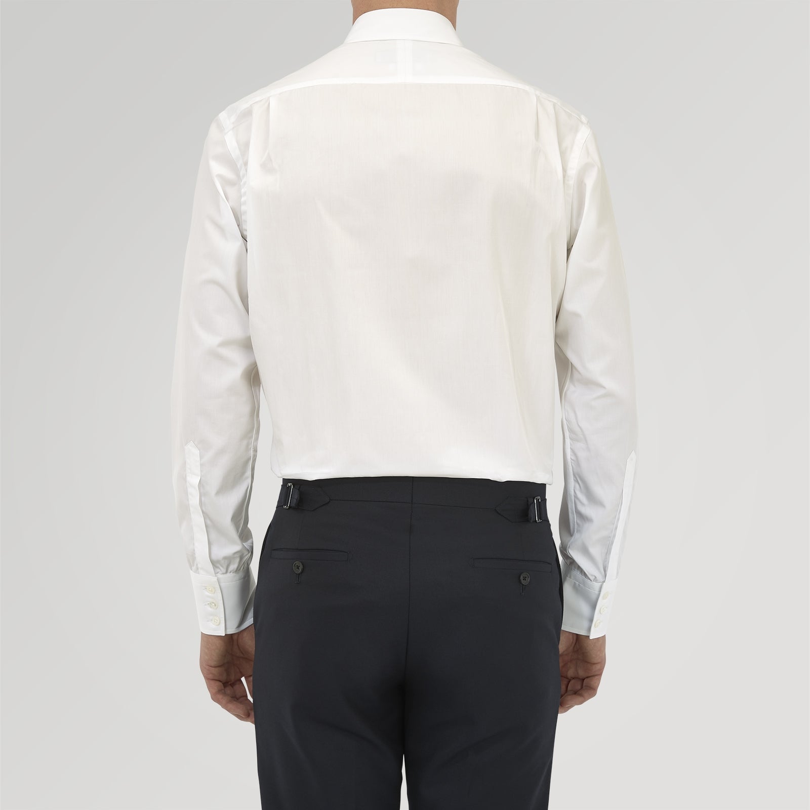 View 4 of product The Turnbull & Asser Tailored Fit Two-Fold 120 White Cotton Shirt features a Kent collar, double cuffs, and button-down front, displayed neatly folded against a light blue background.