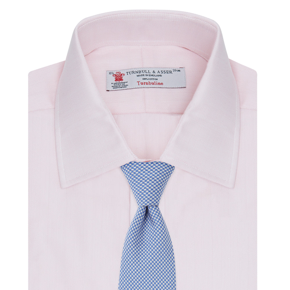 The Turnbull & Asser Pink Herringbone Superfine Cotton Shirt features a T&A collar, double cuffs, and clean-cut design, displayed neatly folded against a white background.
