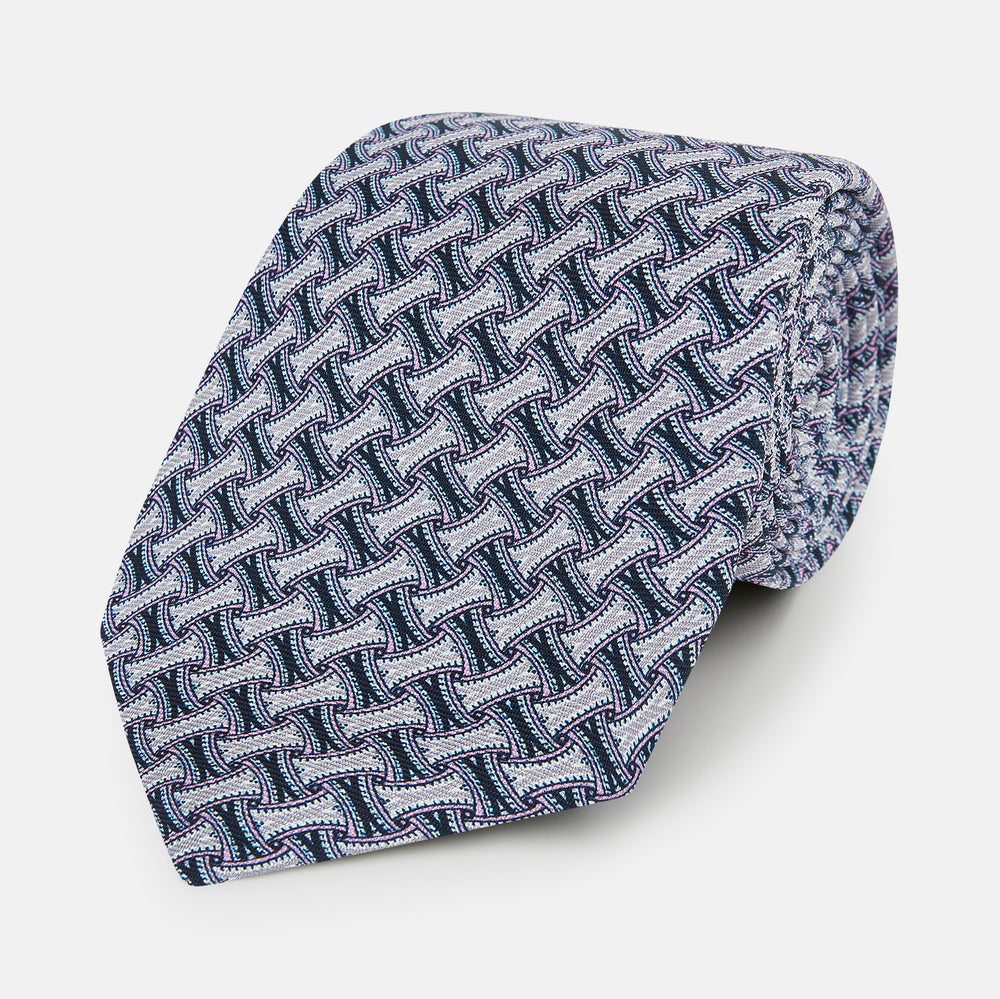 The Turnbull & Asser Navy and Pink Weave Patterned Silk Tie is shown elegantly rolled up on a white background.