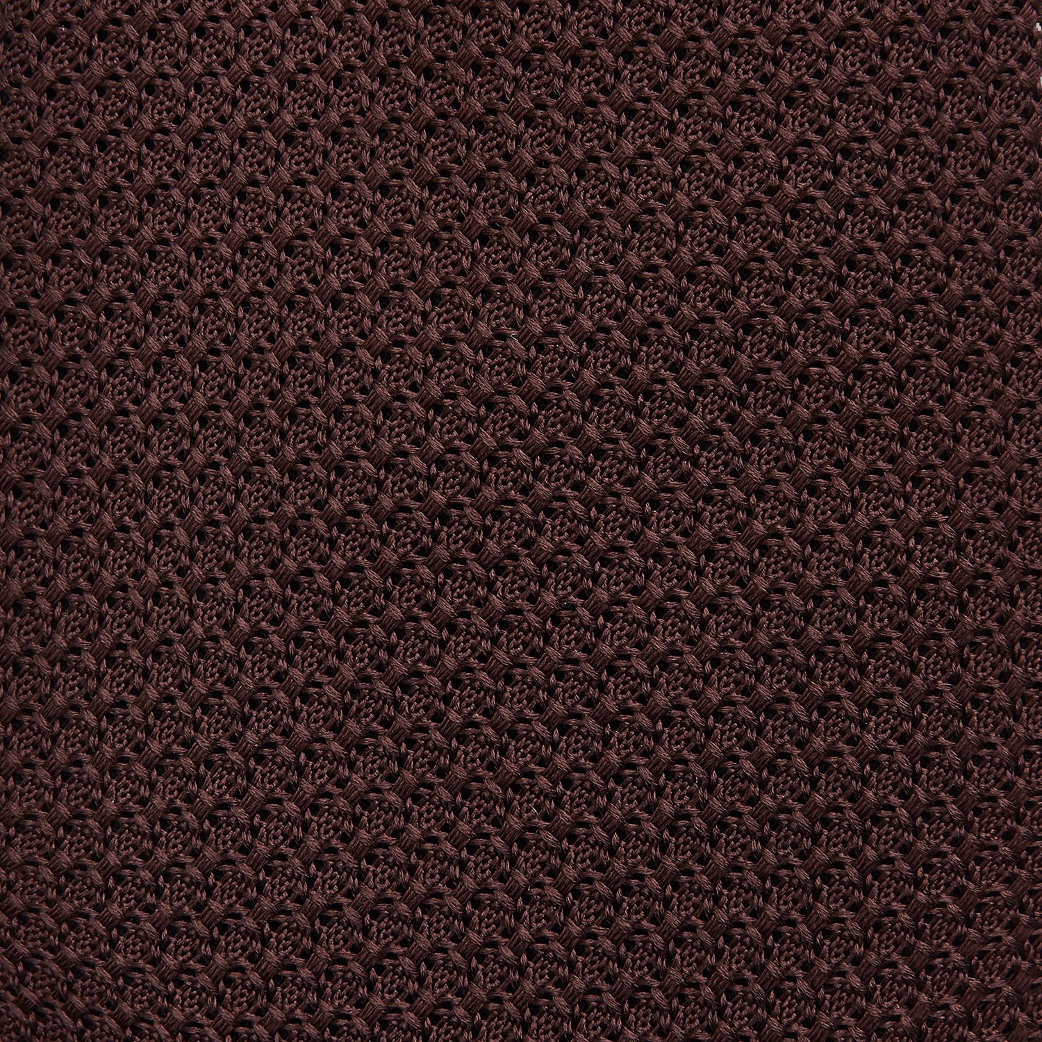 View 3 of product The Turnbull & Asser Ruby Red Knitted Tie, shown rolled-up against a white background, is a textured silk accessory that adds versatile sophistication to any gentleman's wardrobe.