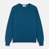 View 2 of product A man with light skin and short brown hair stands against a plain background, wearing the Turnbull & Asser Ocean Blue Merino Kingston Crew Neck Jumper and cream-colored pants, looking directly at the camera with a neutral expression.