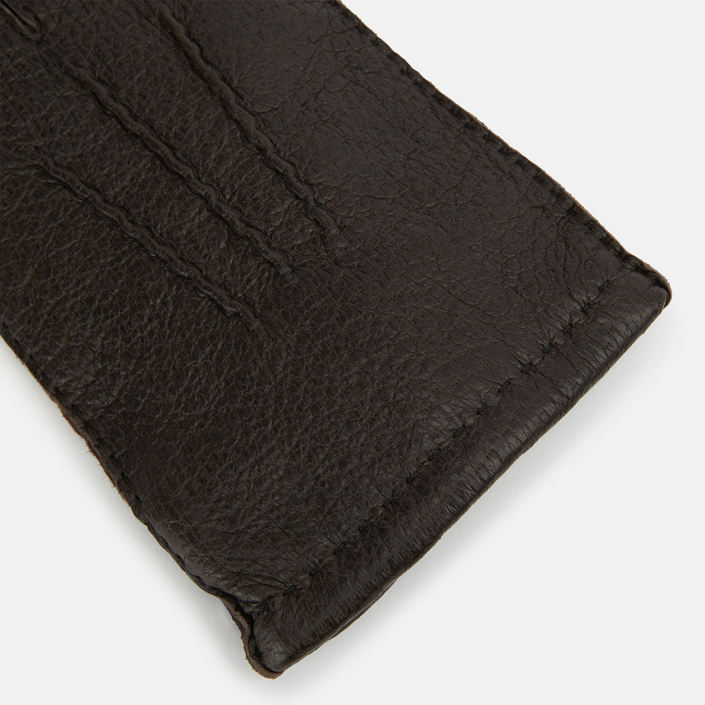 Turnbull & Asser's Dark Chocolate Cashmere-Lined Peccary Leather Gloves feature visible stitching, a buttoned strap on the palm side, and luxurious Scottish cashmere lining for superior comfort.